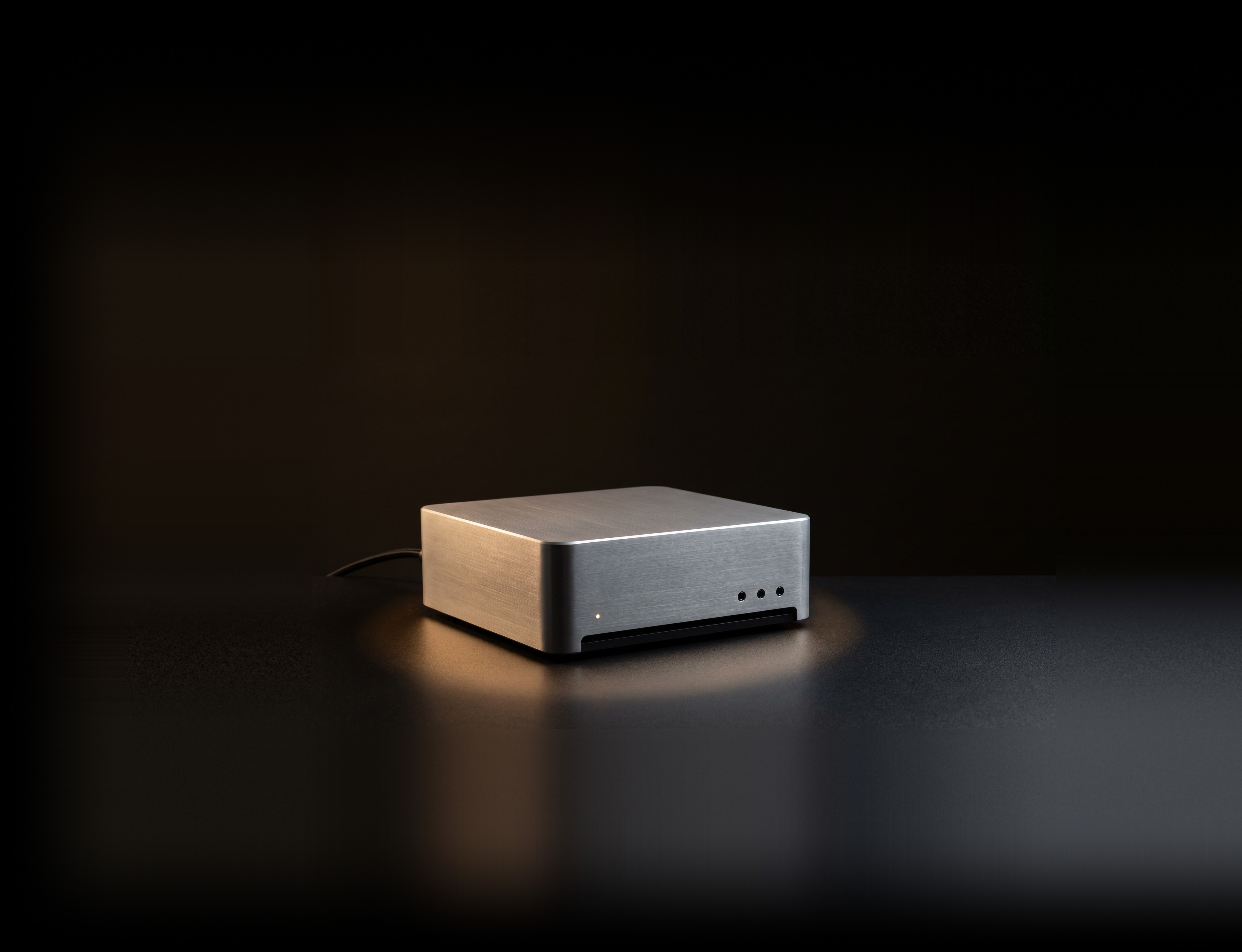 The Production Brain: a compact machine on a studio desk, wired to the tools that feed it and the agents that ask it.